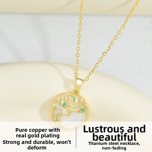 Macro shot of gold deer pendant necklace with emerald green stones and titanium steel chain