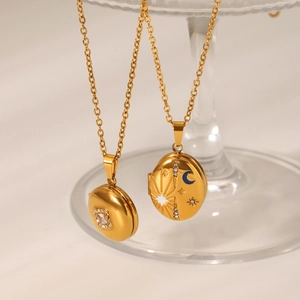 Detail of gold magnetic locket necklaces with engraved sun, star and moon symbols