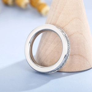 Detail shot of eternity ring with cubic zirconia stones on a wooden jewelry display stand