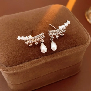 Macro view of silver teardrop earrings with small pearls and sparkling zircons