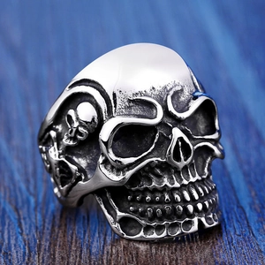 Macro shot of silver skull ring detail with gothic oxidation and embossed patterns
