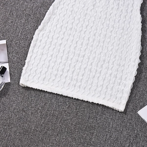 Vue détaillée du tissu blanc en gaze gaufrée avec texture plissée élastique et fronces