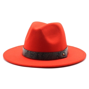Detail of red wool fedora featuring a faux snakeskin leather band and gold stud accent