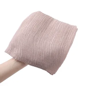 Detailed macro view of the pleated texture on a soft dusty pink cotton linen scarf