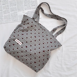 Vue détaillée du sac cabas en toile à carreaux avec pois rouges et nœud brodé
