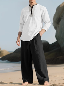 Detail of white linen shirt with geometric print on collar and black beach pants