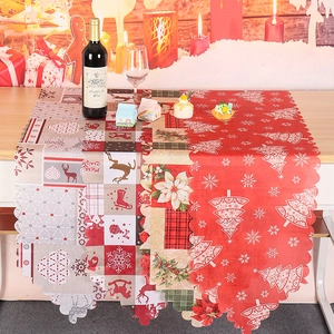Chemin de table de Noël avec motifs renne et flocons sur une table en bois rustique