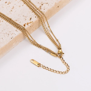 Gold layered stainless steel necklace featuring star and moon pendants and a K18 tag