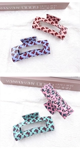 Détail de grandes pinces à cheveux rectangulaires aux imprimés papillons colorés pastel