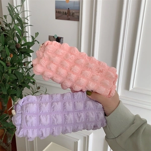 Detailed view of pink and lilac popcorn texture pouches with zipper closure