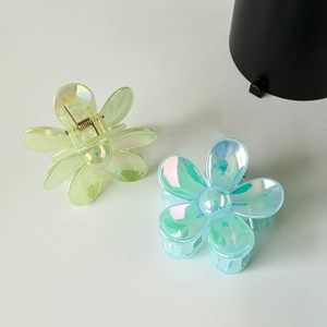 Floral iridescent hair claw clips in light green and blue with a pearlescent finish