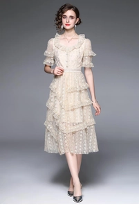 Détails d'une robe en dentelle abricot avec jupe à volants et broderies florales
