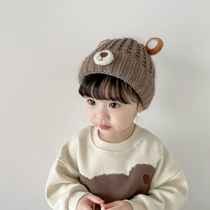 Detailed view of baby winter knit hat with bear ears and matching long sleeve sweater