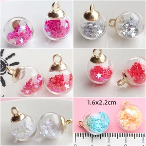 Macro view of 16x22mm crystal glass ball charms with star sequins and size scale
