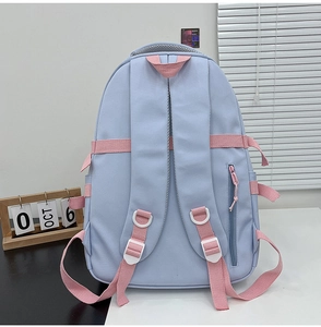 Detail view of the light blue backpack's padded straps and secure back zipper pocket