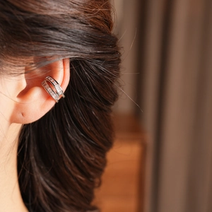 Macro shot of silver double-layered ear cuff with zircons on a model's ear