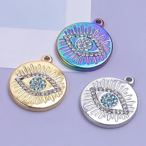 Makro-Detail von drei Evil-Eye-Anhängern in Gold, Silber und Regenbogen-Edelstahl