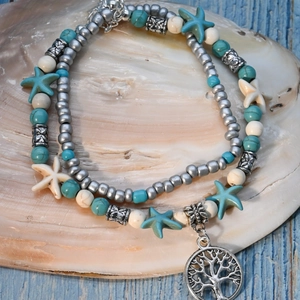 Detail of beaded layered anklet with starfish pendants and tree of life in a seashell