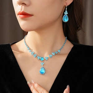 Dettaglio del set collana e orecchini in argento con cristalli blu a goccia su modella