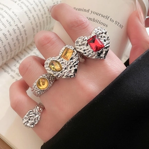 Detail of vintage silver lava texture rings with colorful resin gems on a hand