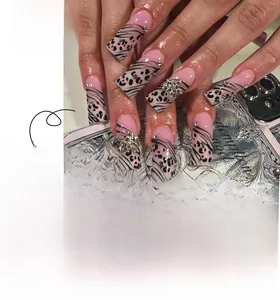 Detail of pink press-on nails featuring leopard print, zebra patterns, and silver 3D stars