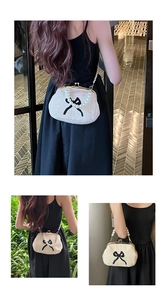 Détail d'un sac en paille tissé main avec bandoulière perle et motif nœud noir