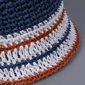 Close-up of a striped handmade crochet bucket hat in navy, white and rust.