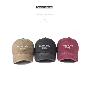 Detailed embroidery on vintage washed cotton baseball caps in khaki, black, and burgundy