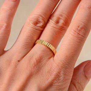 Makroaufnahme des vergoldeten S925 Silberrings mit vertikaler Streifenstruktur am Finger