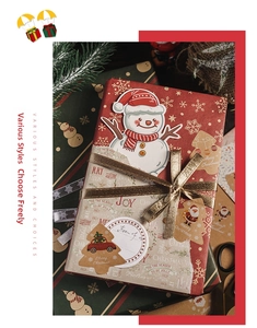 Flat lay of Christmas gift boxes with kraft stickers, golden ribbons, and pine needles