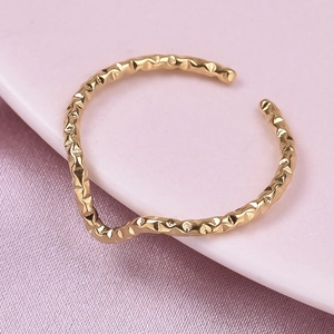 Close-up of golden adjustable ring with unique hammered texture and wavy line design