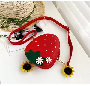 Close-up of a red strawberry-shaped PU leather crossbody bag with floral leaf details