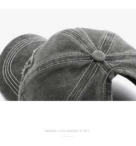 Macro shot of charcoal grey washed cotton baseball cap with white contrast stitching details
