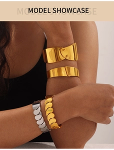 Model wearing gold and silver hip hop style chunky titanium steel bangles and chain bracelets