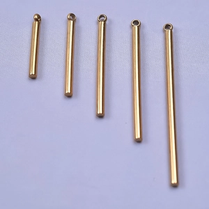 Detailed macro view of five golden stainless steel bar pendants in varying lengths