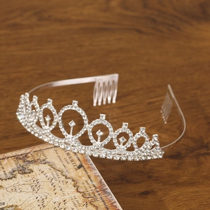 Elegant silver rhinestone tiara crown with comb on vintage wooden background