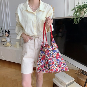 Detailed close-up of a floral canvas tote bag with drawstring and Sozakka label
