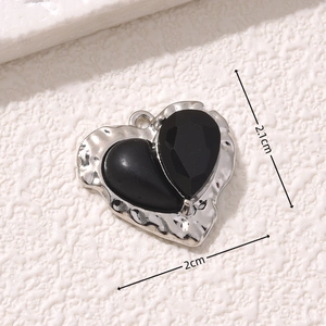 Macro shot of asymmetric black heart pendant with dimensions 2.1cm and 2cm