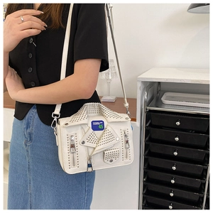 Detailed shot of white motorcycle jacket shaped crossbody bag with silver punk rivets