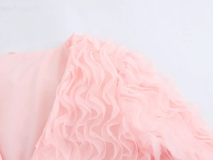Détail macro du tissu en résille rose tendre avec textures volantées et bords ondulés