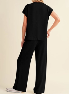 Detail of black ribbed knit two-piece set featuring short sleeve top and wide leg pants