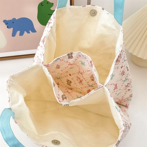 Detail of floral canvas bag showing multiple compartments and magnetic snap closure