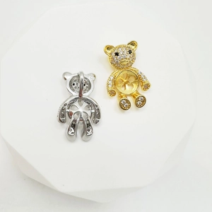 Detail of silver and gold bear-shaped pendant charms with rhinestone pavé inlay