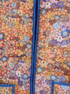 Détail du tissu matelassé à imprimé floral Y2K et liseré bleu contrasté
