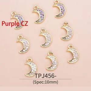 Macro shot of 10mm gold-plated crescent charms with purple cubic zirconia for DIY jewelry