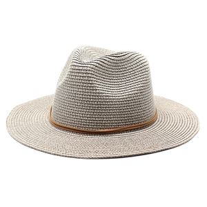 Close-up detail of the fine woven texture and brown leather band on the straw fedora hat