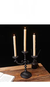 Detailed close-up of a vintage 3-arm metal candelabra with flickering lit white candles