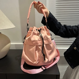 Détail du sac seau en tissu rose avec fermeture par cordon et boucles métalliques