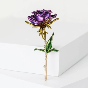Detail of purple enamel rose brooch with gold leaves on white platform pedestal