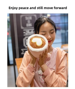 Detailed latte plushie with pink cup and heart latte art held in a cafe setting